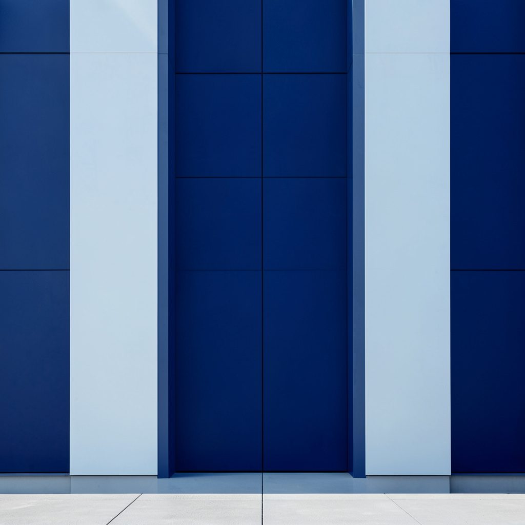 A clean architectural photograph of a modern transportation hub interior with strong symmetry, warm neutral tones, and soft natural light filtering through large windows.